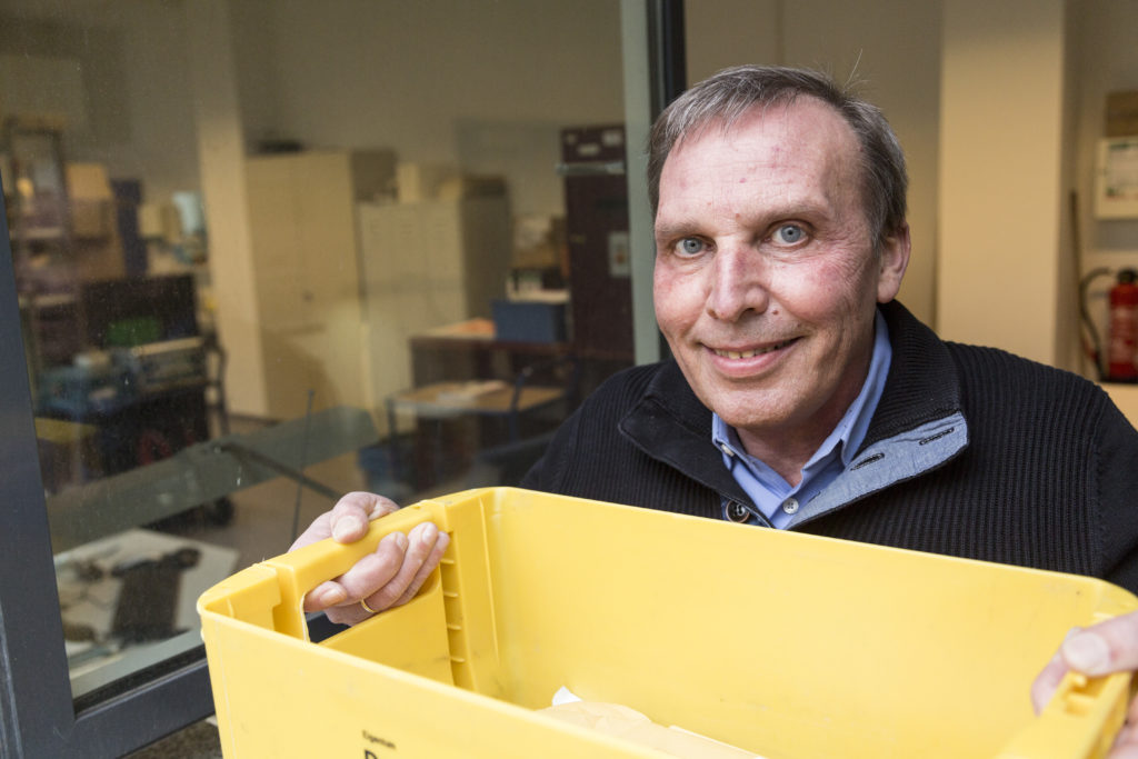 Ralf Dorschel hält einen gelben Postkorb hoch.